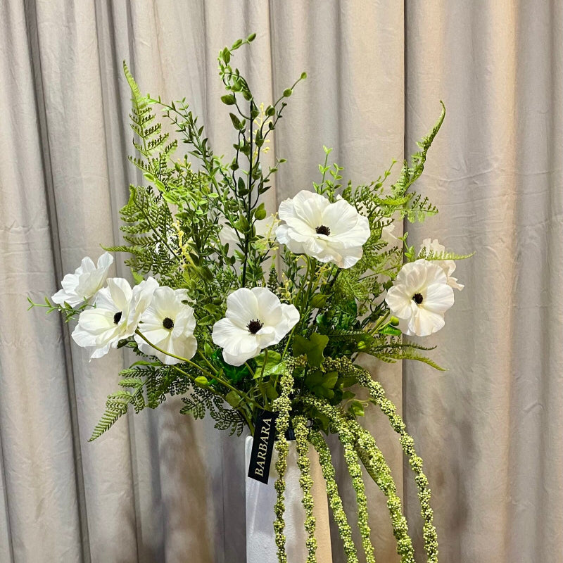 Grønt bregneblad i buket med kunstige blomster