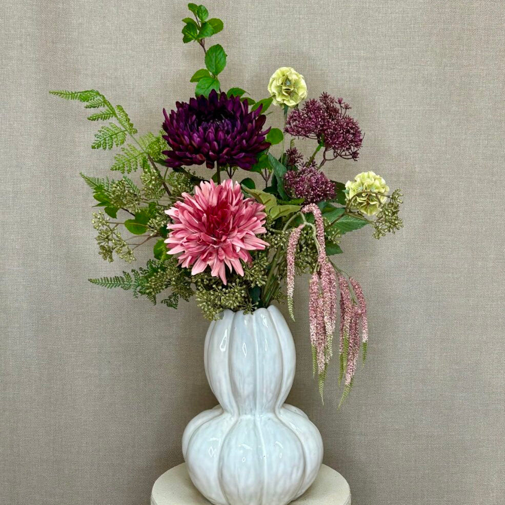 Grøn kunstig kørvel i en blandet buket med rosa og lilla blomster